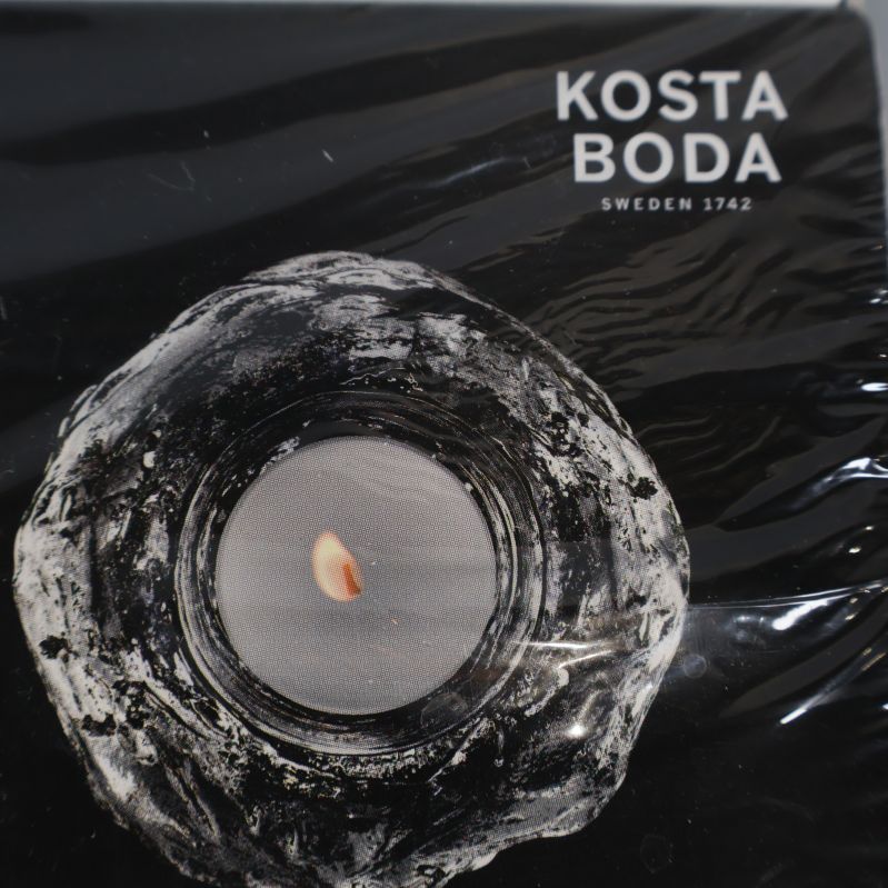 Närbild på Kosta Boda logotyp och glasljusstake