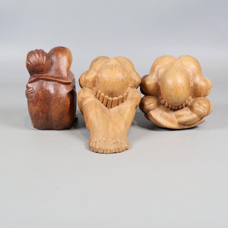 Tre sittande träskulpturer med olika former