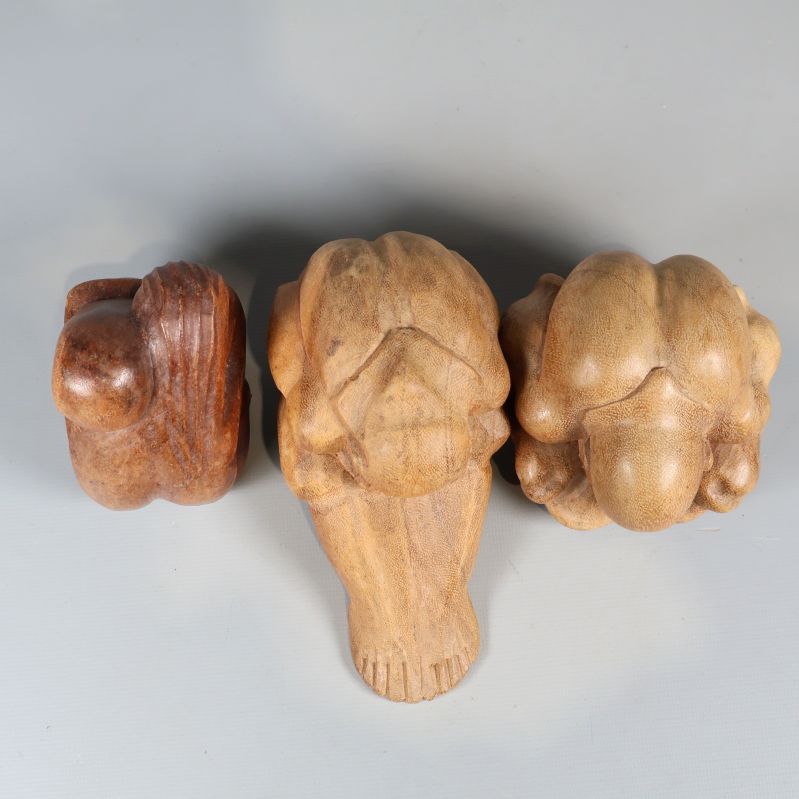 Tre sittande träskulpturer sedda uppifrån