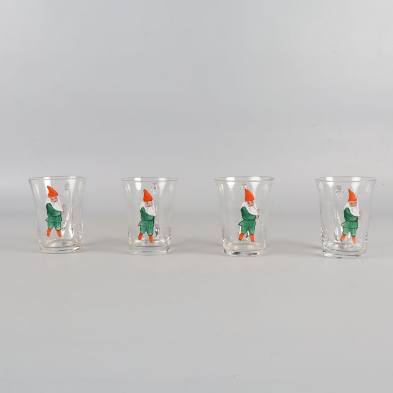 Fyra glas med tomtemotiv uppställda på rad