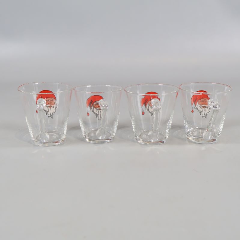 Frontal vy av fyra tomteprydda glögglas på rad
