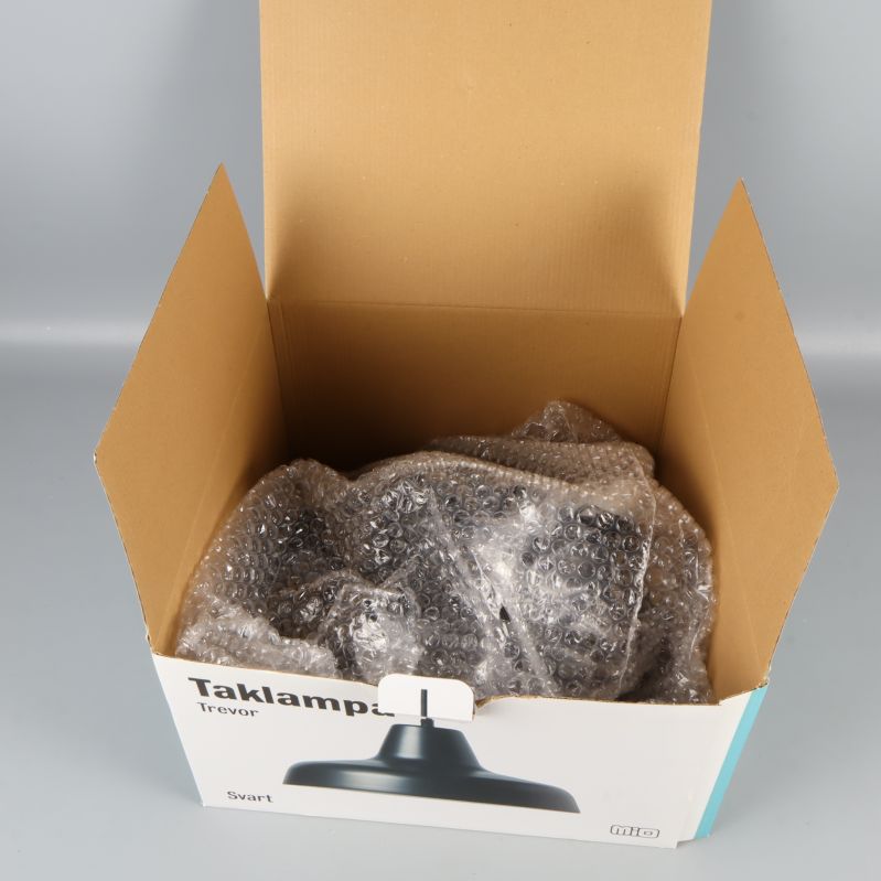 Taklampa nedpackad i öppen kartong med bubbelplast
