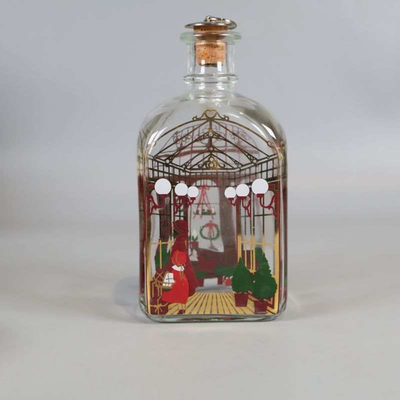 Karaff i glas sedd rakt bakifrån, julmotiv och kork synliga