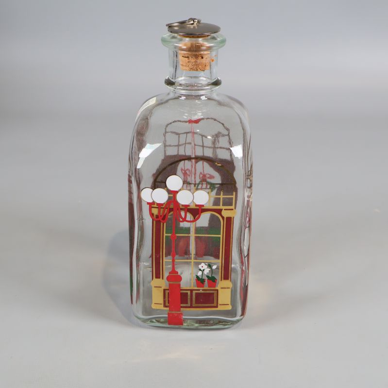 Karaff i glas med färgglada juldekorationer, sidovy