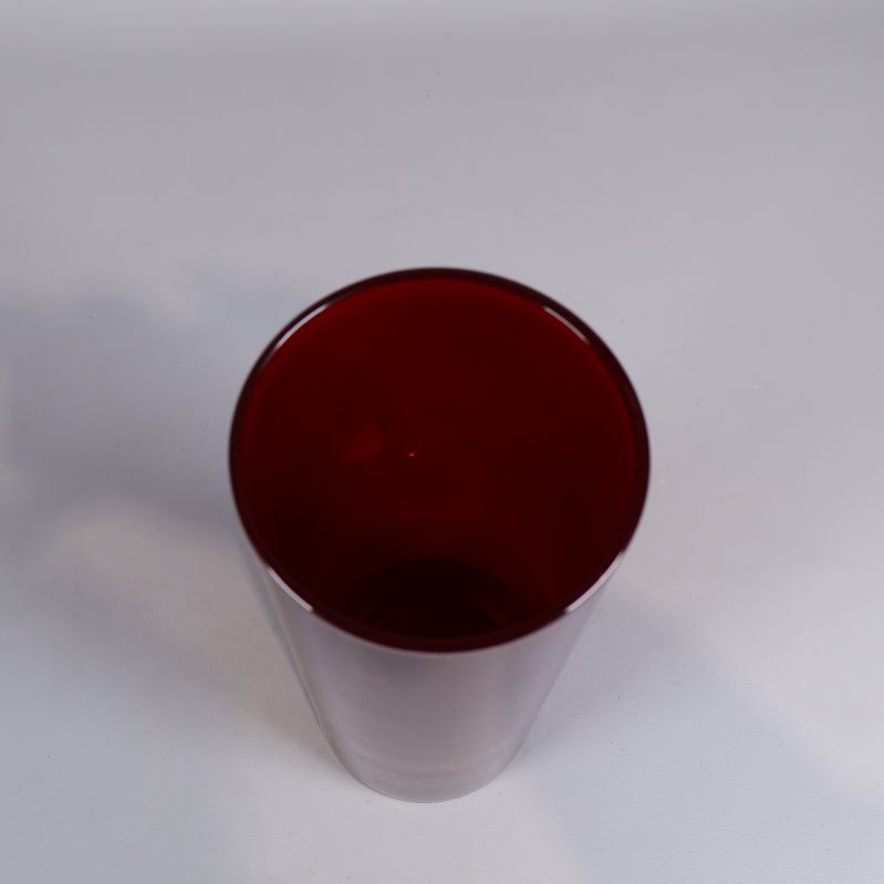 Röd cylinderformad vas fotad uppifrån med synlig insida