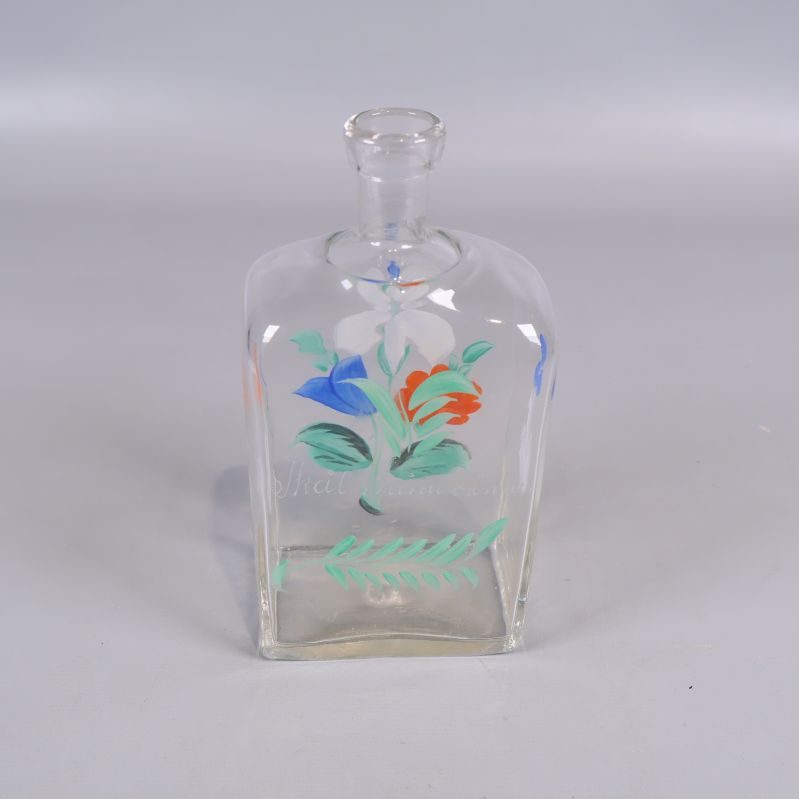 Klar glasflaska med målad dekor av blommor framtill