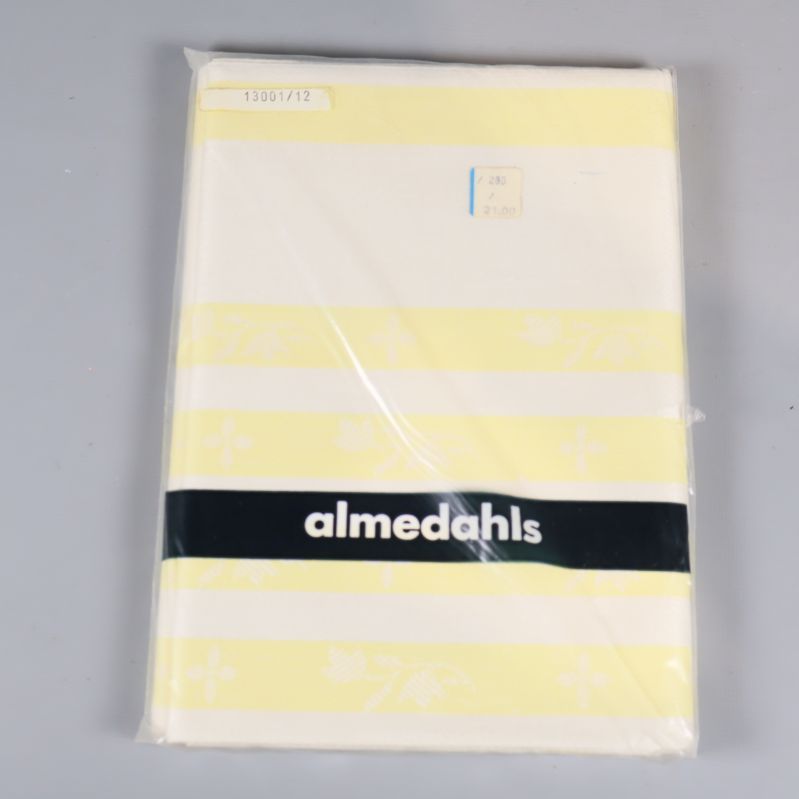 Linnehandduk i förpackning med gulvita ränder och almedahls logotyp
