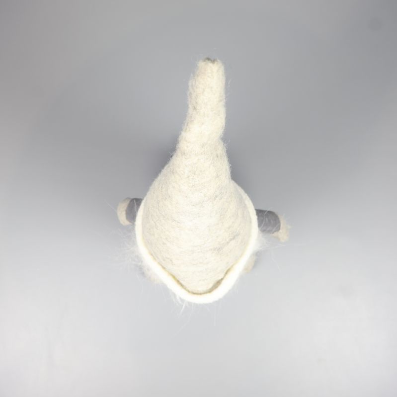 Tomtefigur sedd uppifrån med spetsig gråvit luva