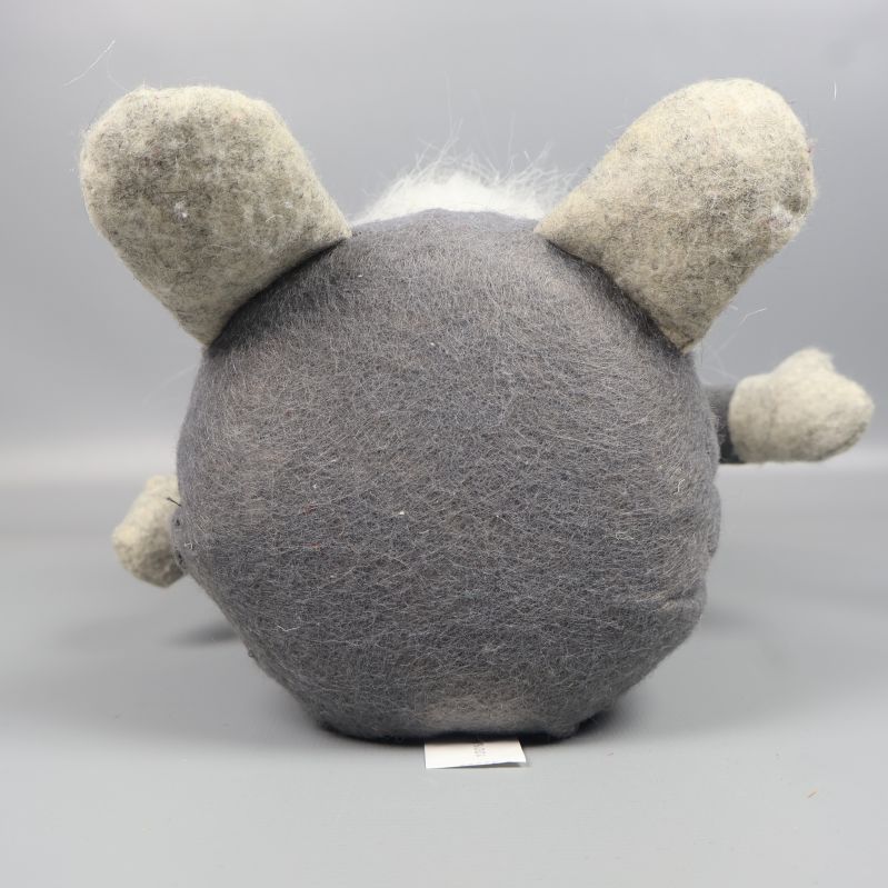 Tomtefigur liggandes på rygg med rund bas och grå ben