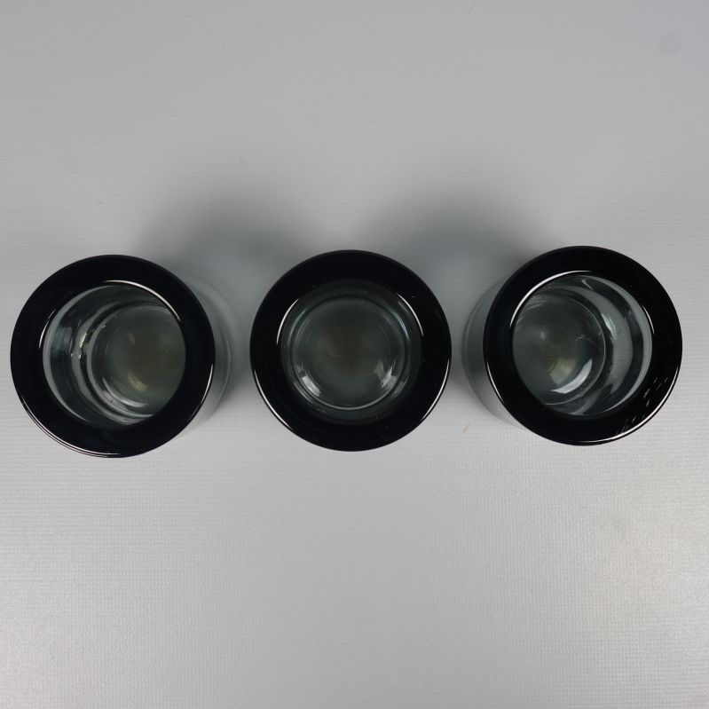 Topdownvy över tre mörkgrå glasljuslyktor