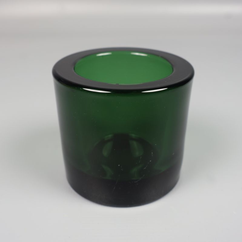 En grön cylindrisk ljushållare i närbild