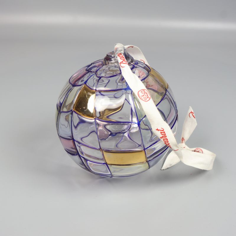Julkula av glas med lila och guldfärgade detaljer och vitt band