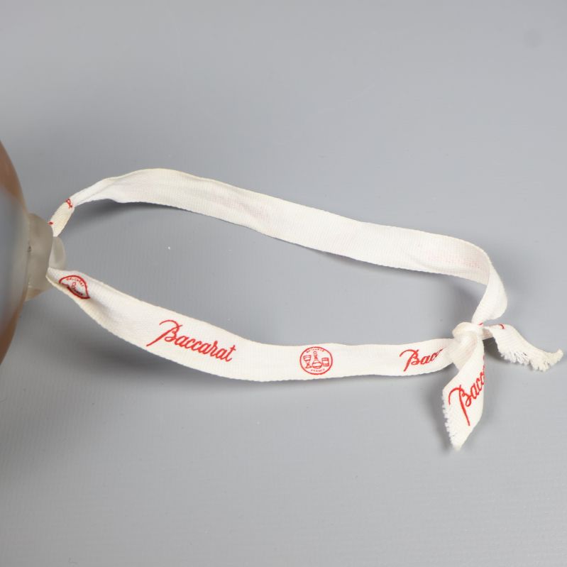 Vitt dekorband med röd Baccarat-logga
