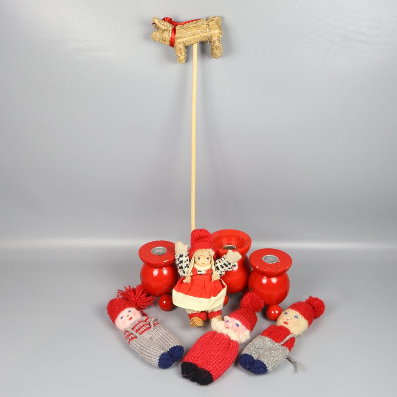 Flera juldekorationer med tomtar, halmbock och röda träljusstakar