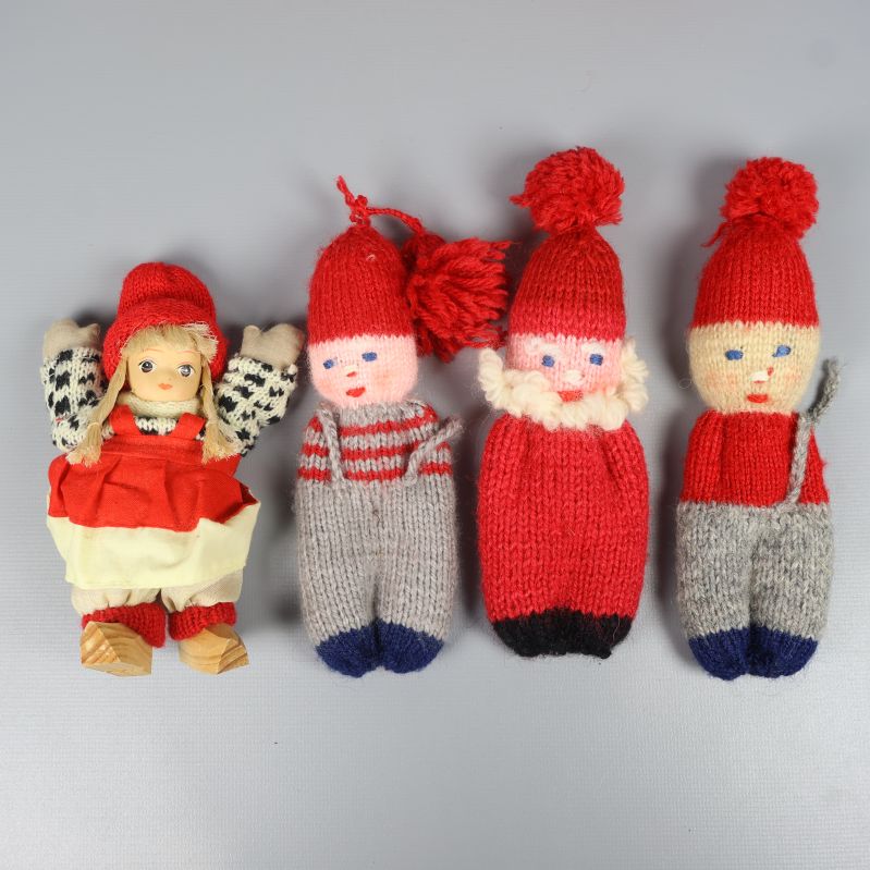 Fyra stickade julfigurer i olika färgställningar
