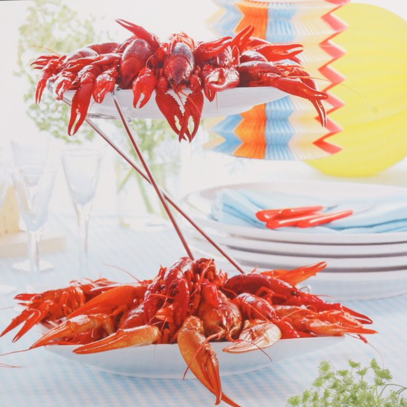 Tvåvåningsfat fyllt med kräftor på festligt dukat bord