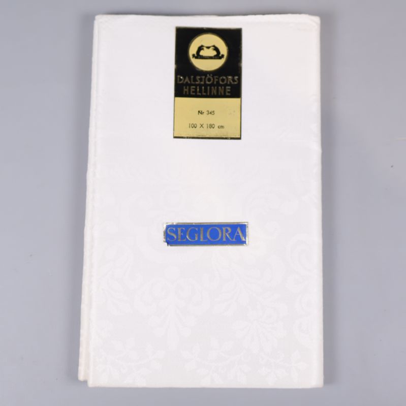 Vikta vit linnelinneduk med etikett Dalsjöfors Hellinne