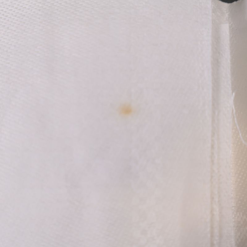 Mindre ljusbrun fläck på naturvit duk