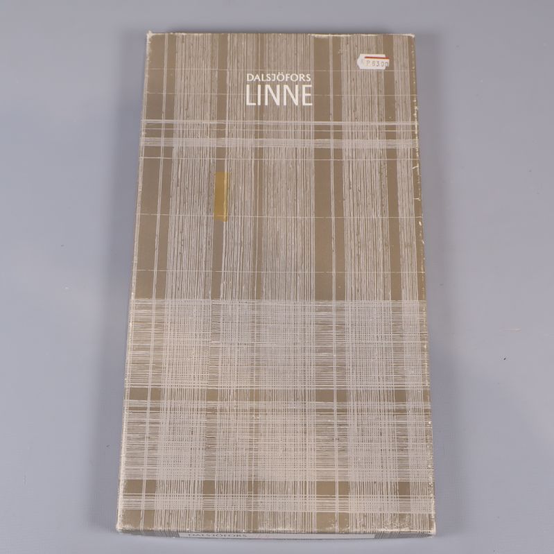 Förpackning med texten Oskarströms Linne i rutigt mönster