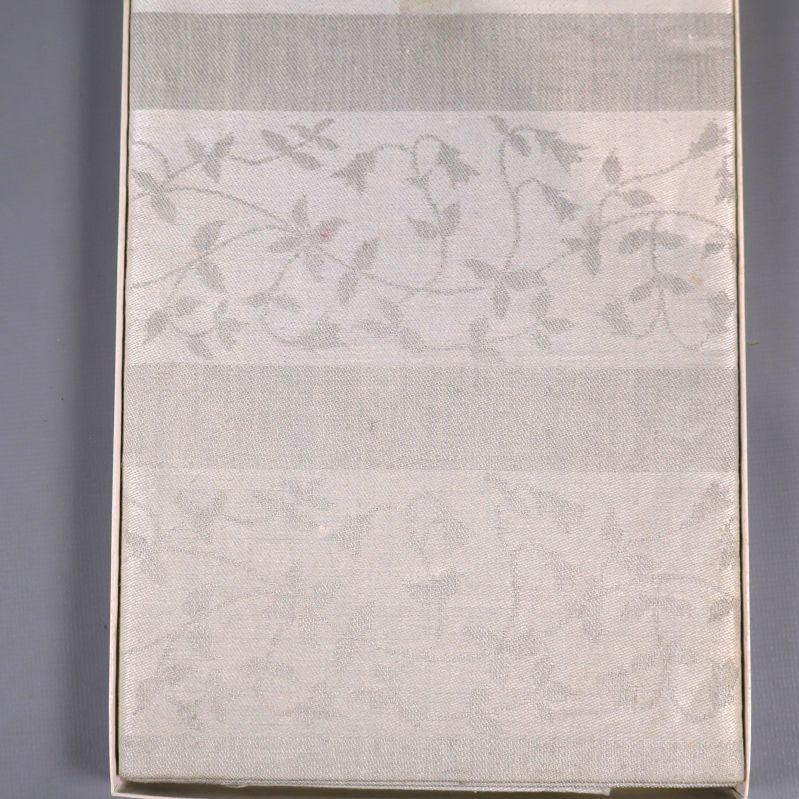 Närbild på linneduken med diskret blommönster