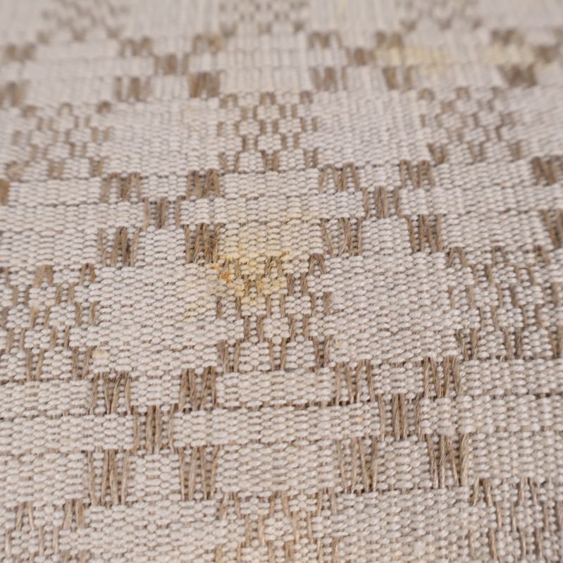 Närbild på mindre gul fläck på duken