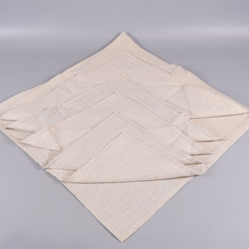 Flera beiga servetter utlagda över varandra 