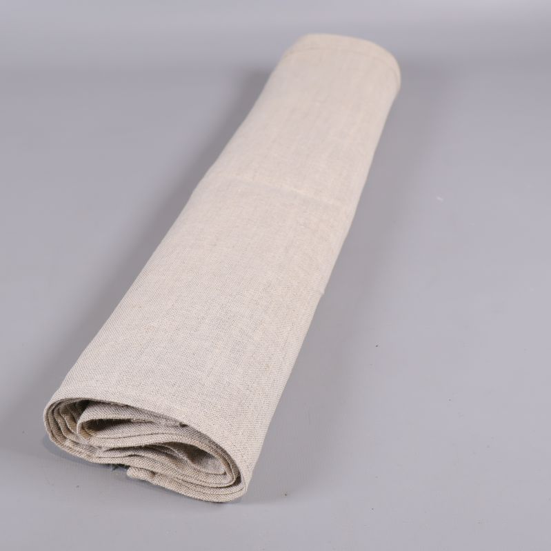 En rulle av beige tygservetter på grå bakgrund