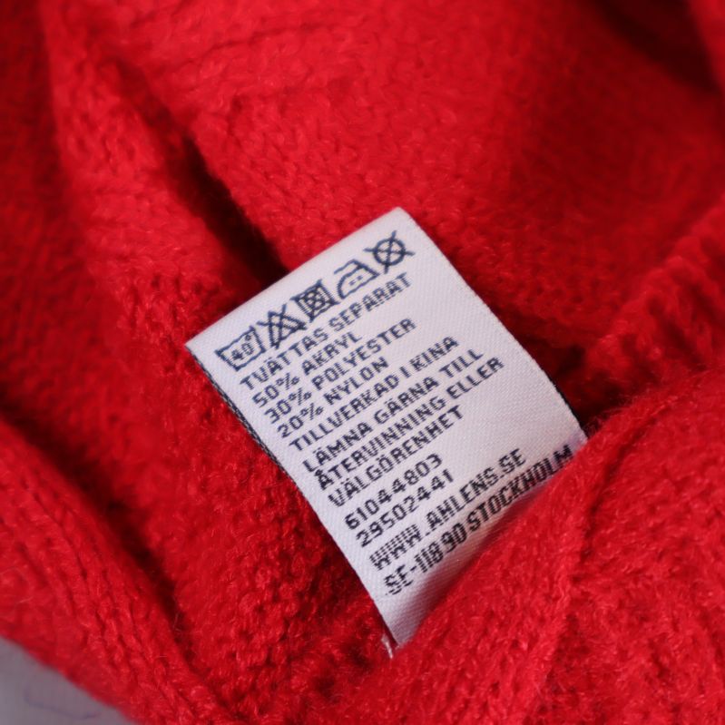 Materialetikett visar komposition och skötselråd för pläden