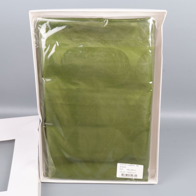 Grön duk i plastförpackning inuti ask