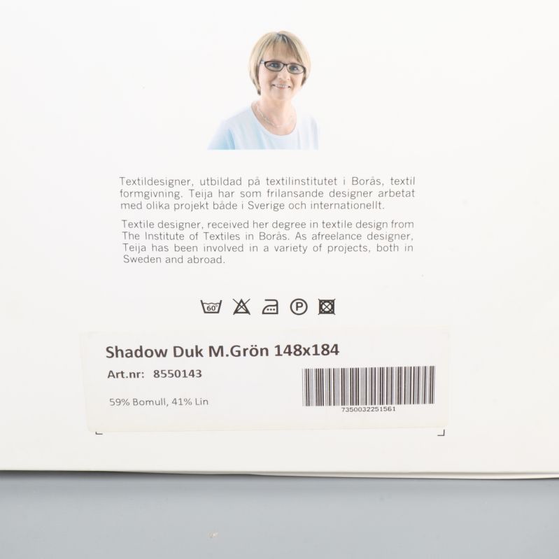 Närbild på etikett med material och mått på duken