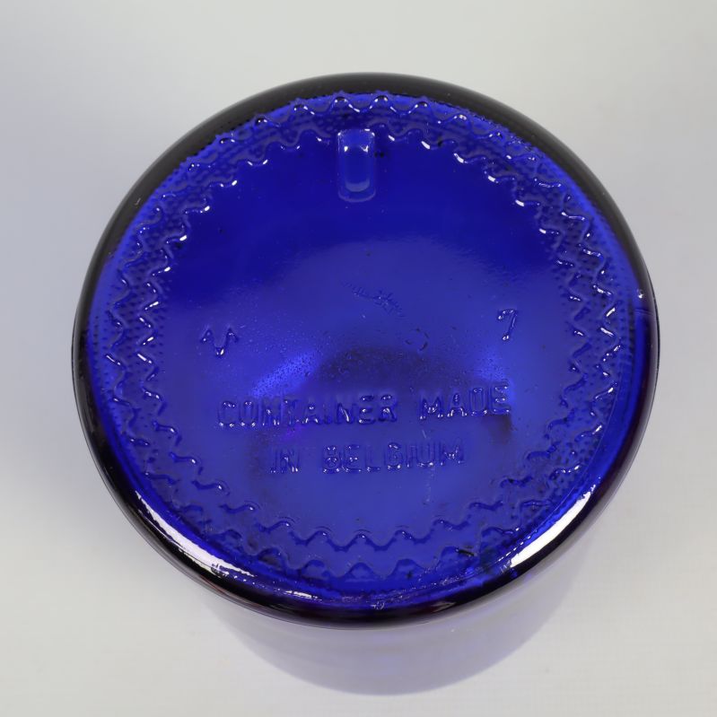 Botten av blå apoteksburk med präglad text