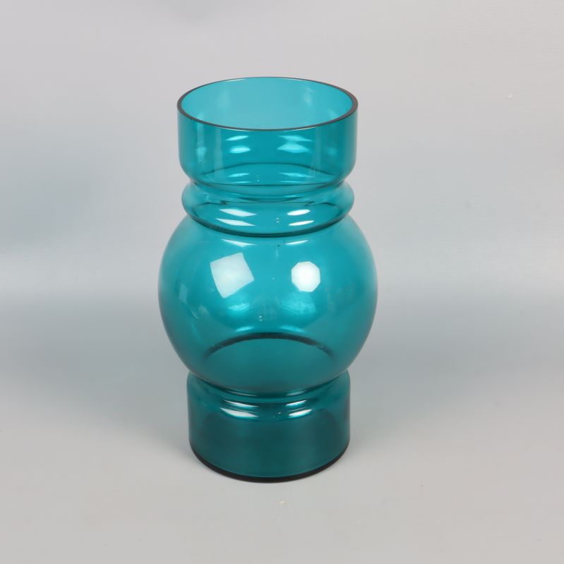 Vas i blått glas med rund form mot grå bakgrund