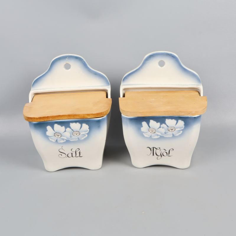 Två väggburkar med blommotiv och trälock framifrån