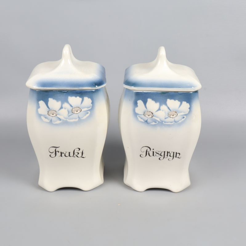 Två burkar med lock, blå och vita med blommönster