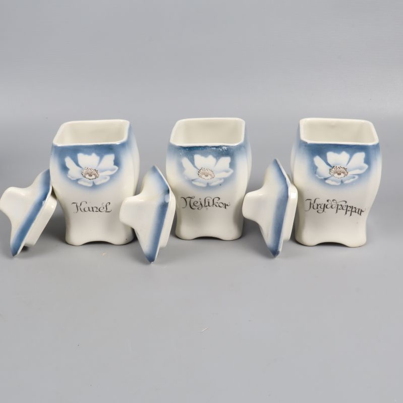 Tre öppna kryddburkar med lock bredvid