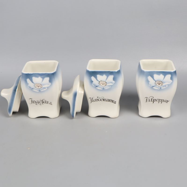 Tre kryddburkar med namn på framsidan och lock avtagna