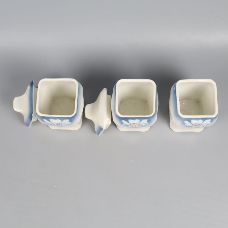 Tre fyrkantiga kryddburkar uppifrån med lock bredvid