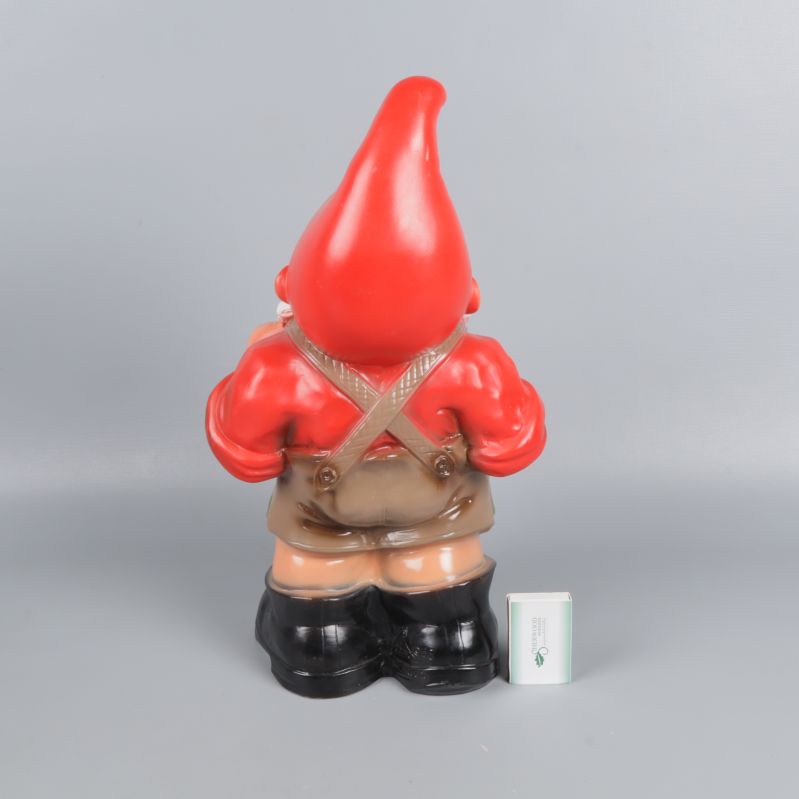 Baksidan av trädgårdstomte med röd luva och stövlar