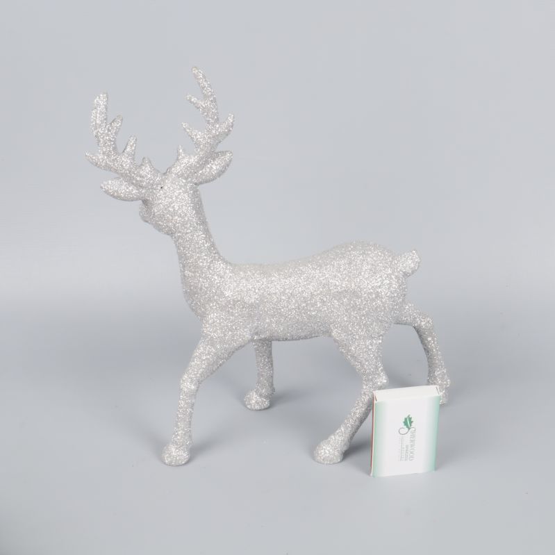 Silverglittrig ren i närbild med storlek jämförd med ask