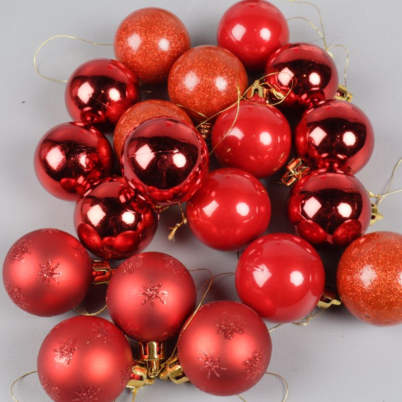 Närbild av flera röda julgranskulor med olika glans