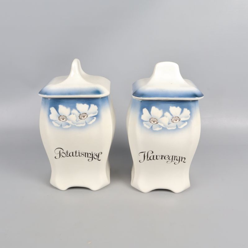 Två burkar med lock och blå blommotiv framtill