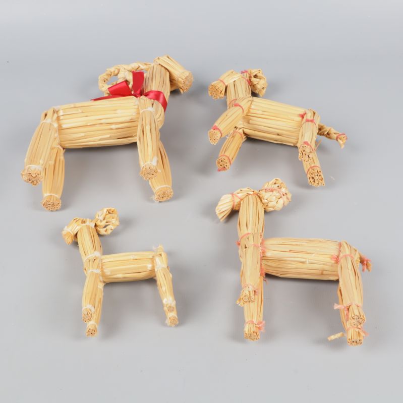 Fyra halmbockar liggande ned mot grå bakgrund