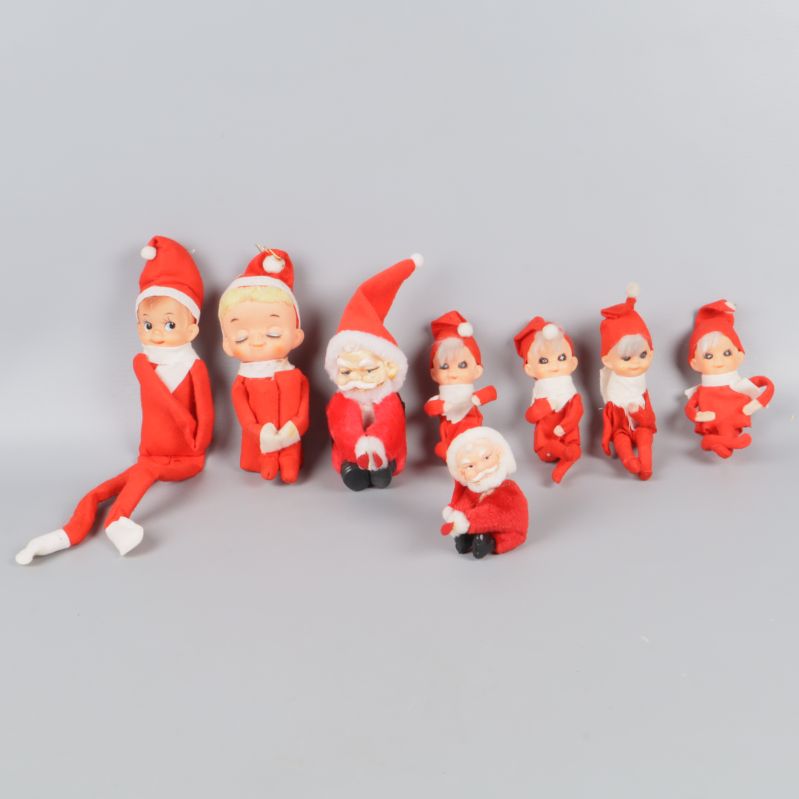 Sju små tomtar i röda kläder mot grå bakgrund