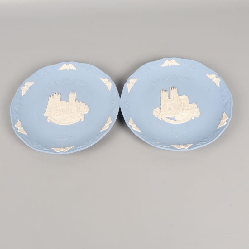 Två blå tallrikar med reliefdekor och motiv