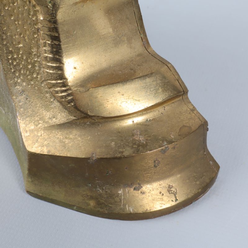 Närbild på klockans gyllene yta med slitagemärken