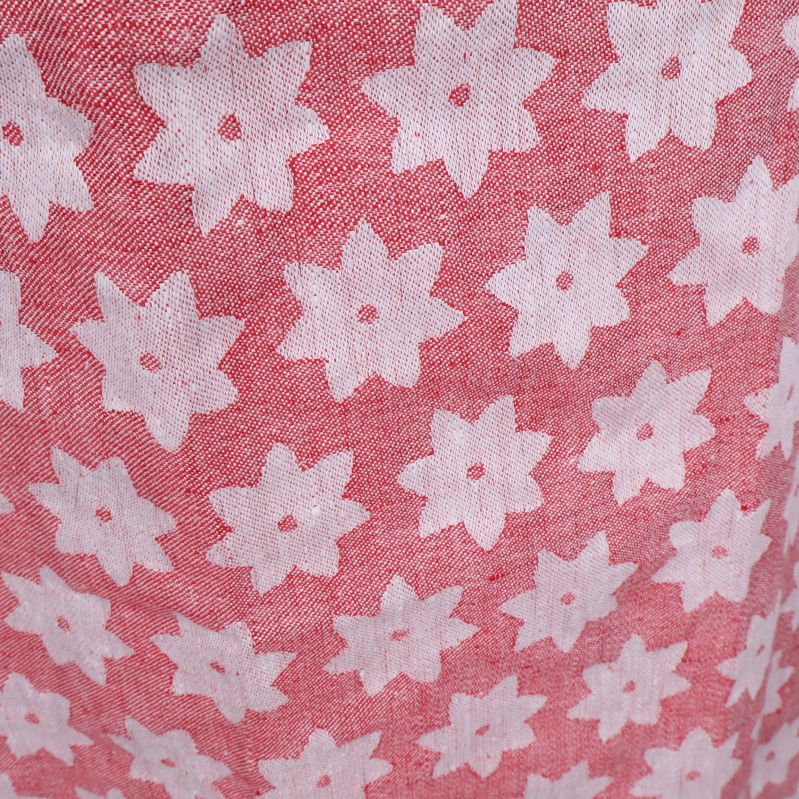 Närbild på rosa tyg med vita blomdetaljer på förkläde