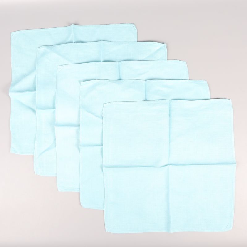 Fem utsträckta ljusblå tygservetter liggande på vit bakgrund