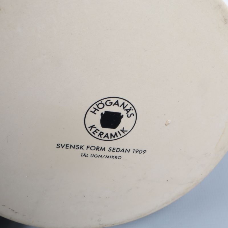 Närbild av Höganäs Keramik logotyp under tekannan