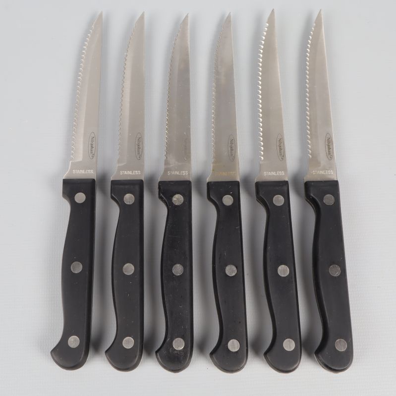 Sex köttknivar med svarta handtag och tandade blad