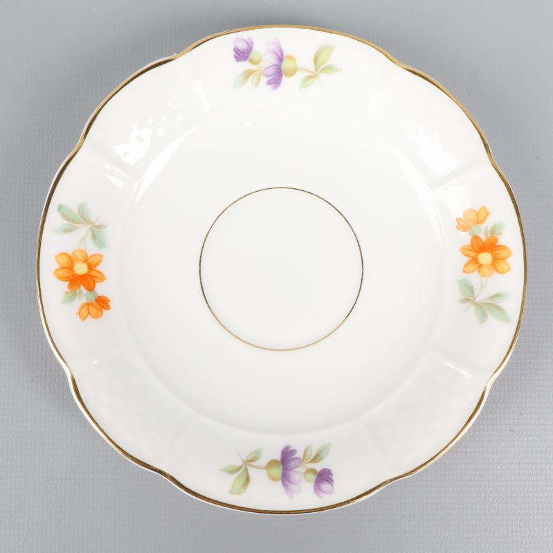 Runt fat med blommönster och guldkant i närbild